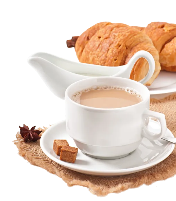 Milchkaffee in einer Tasse, Milchkännchen und Crossaints auf einem Teller
